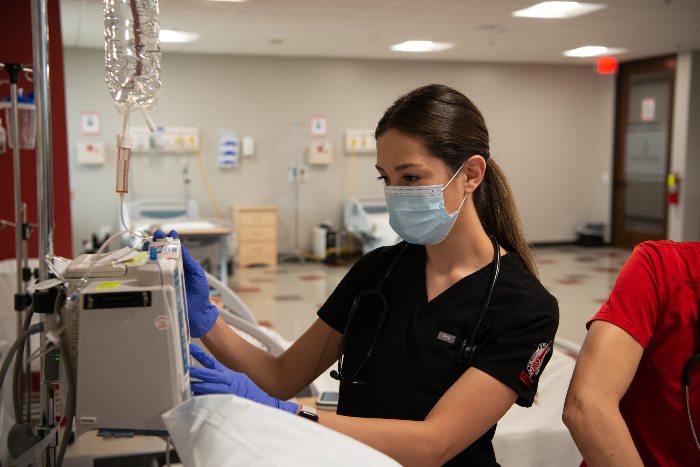 University of the Incarnate Word ABSN student in black scrubs in clinical setting